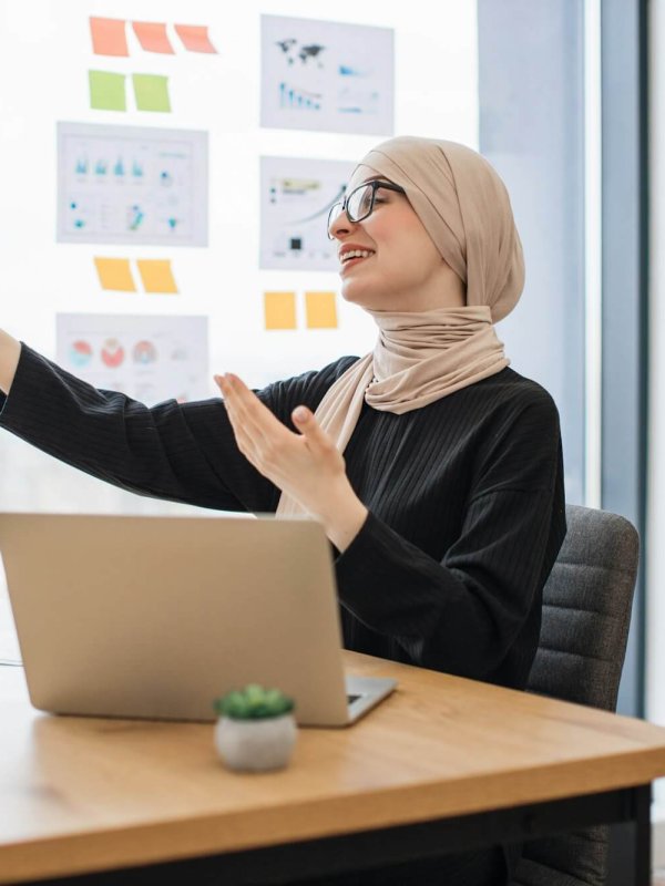 Assistant joining online meeting via phone at office desk